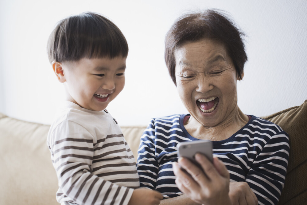 Grandma & grandson laughing watching phone